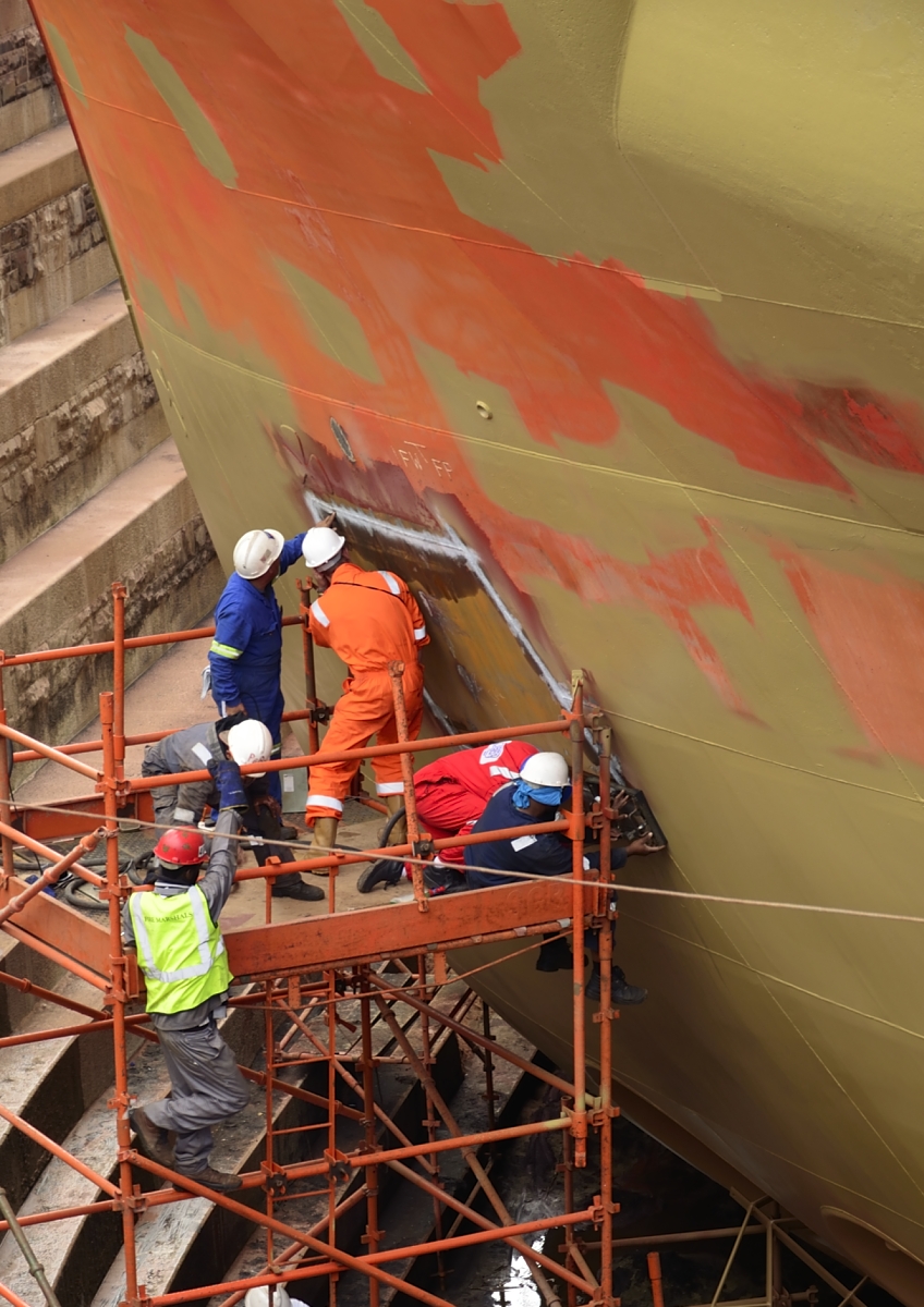 large ship at docks being repaired and repainted